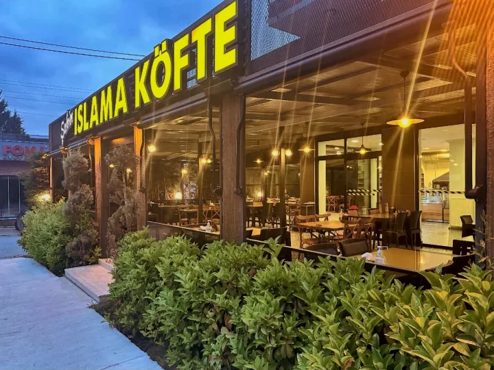 Şahin Islama Köfte’nin akşam ışıklarıyla aydınlanan terası ve tabelası